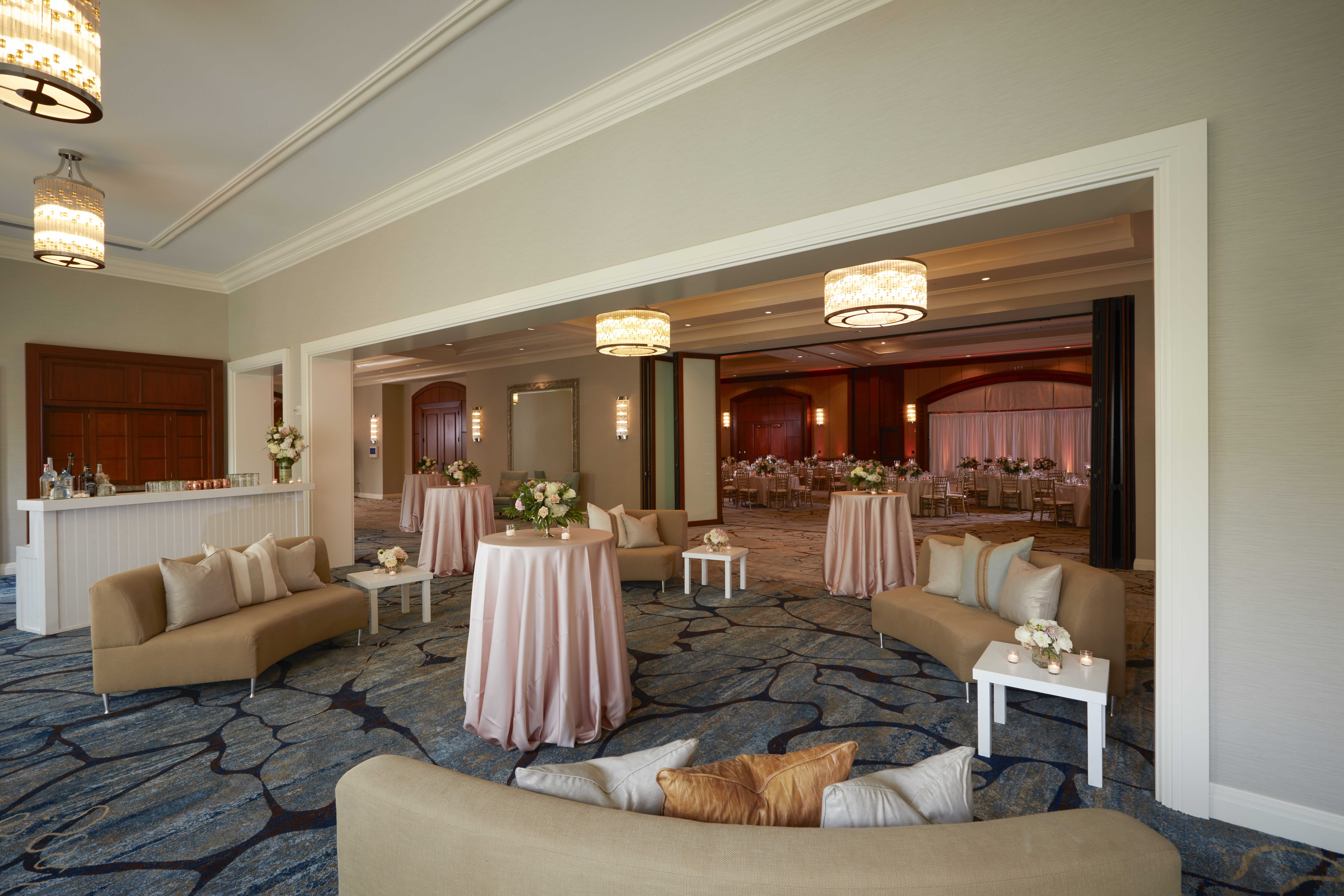 Wedding reception foyer with blush linen cocktail tables at a Houston hotel ballroom event